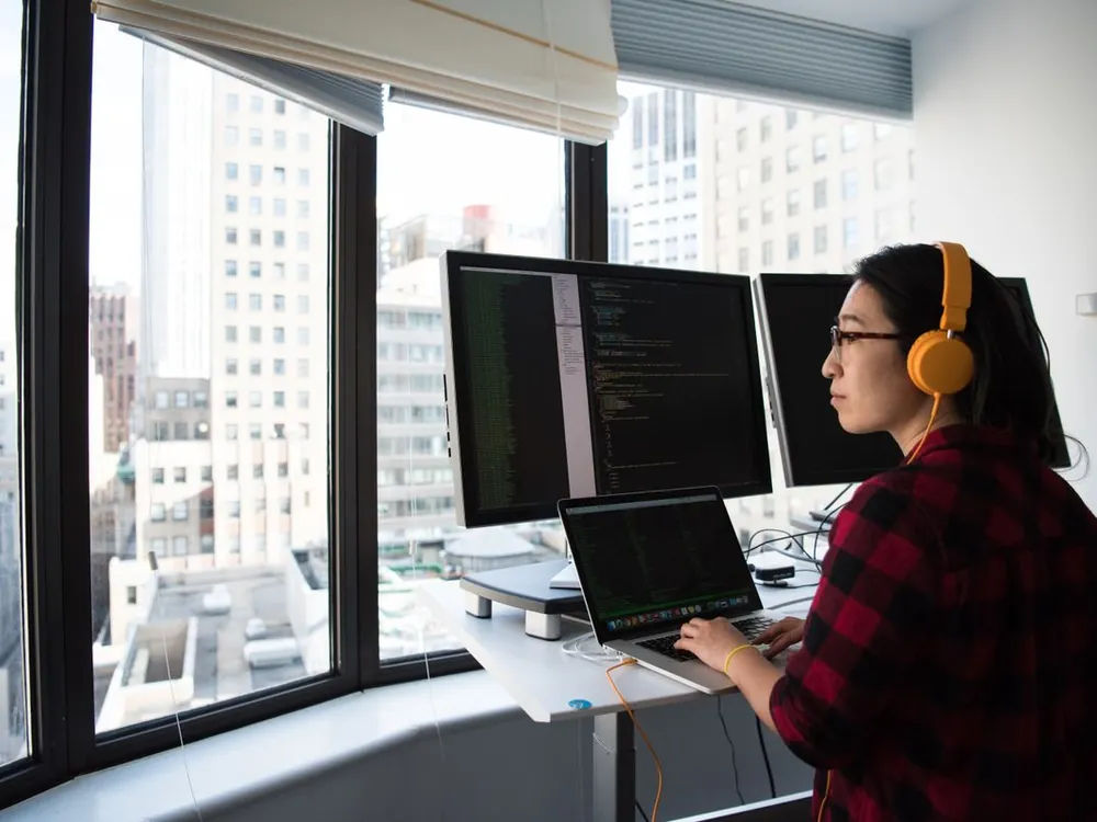 Developer working at a standing desk with two monitors