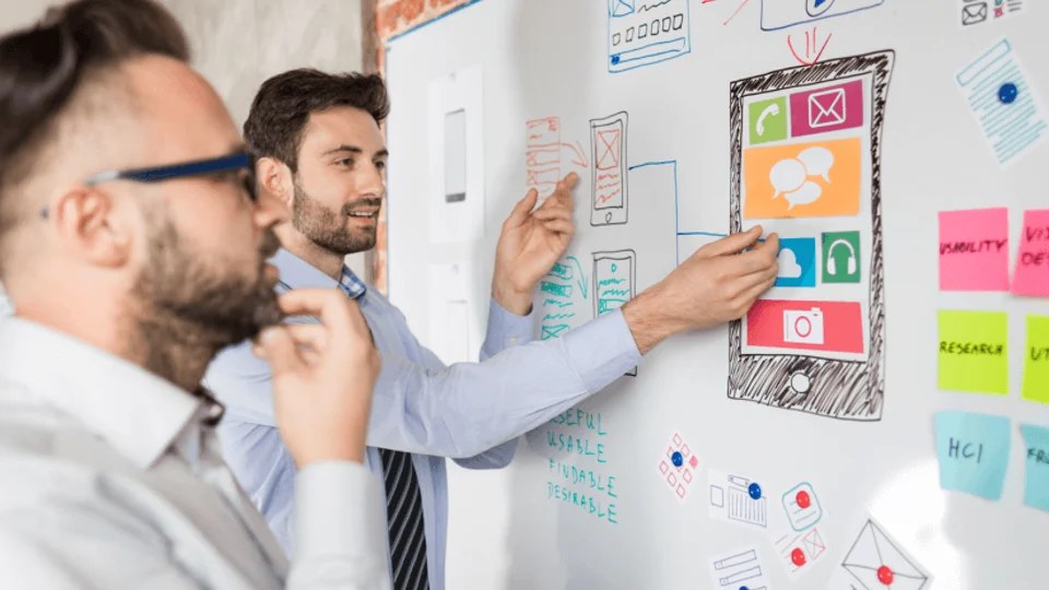 Colleagues discussing project requirements at a planning wall