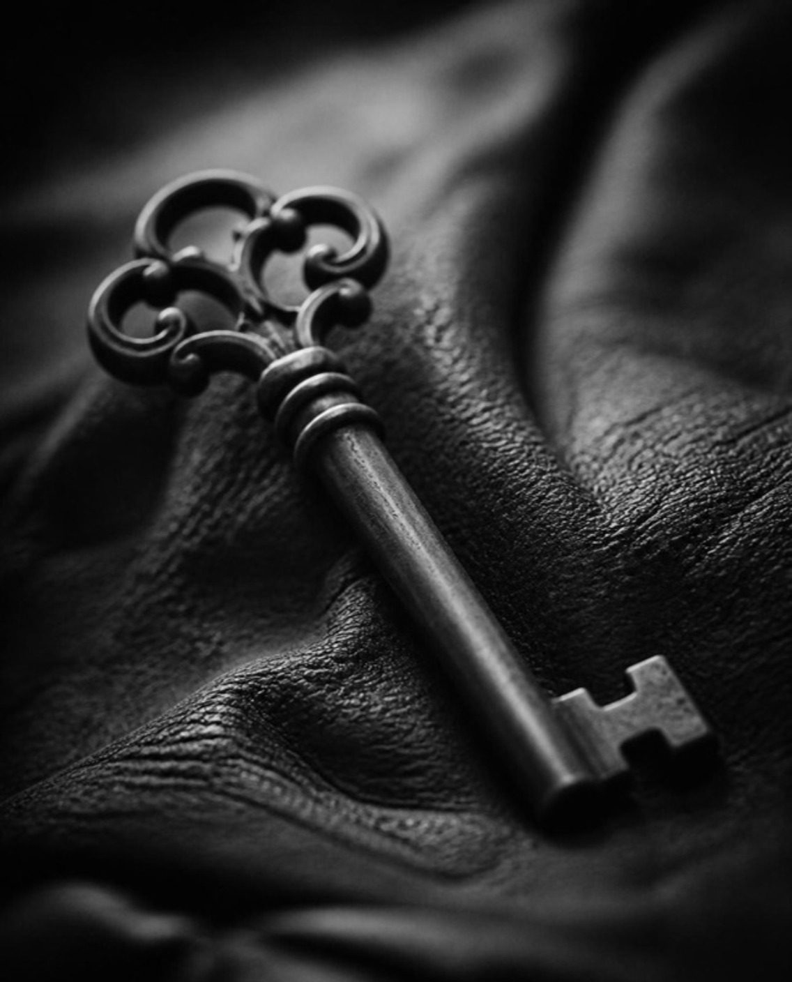 An antique key resting on dark leather